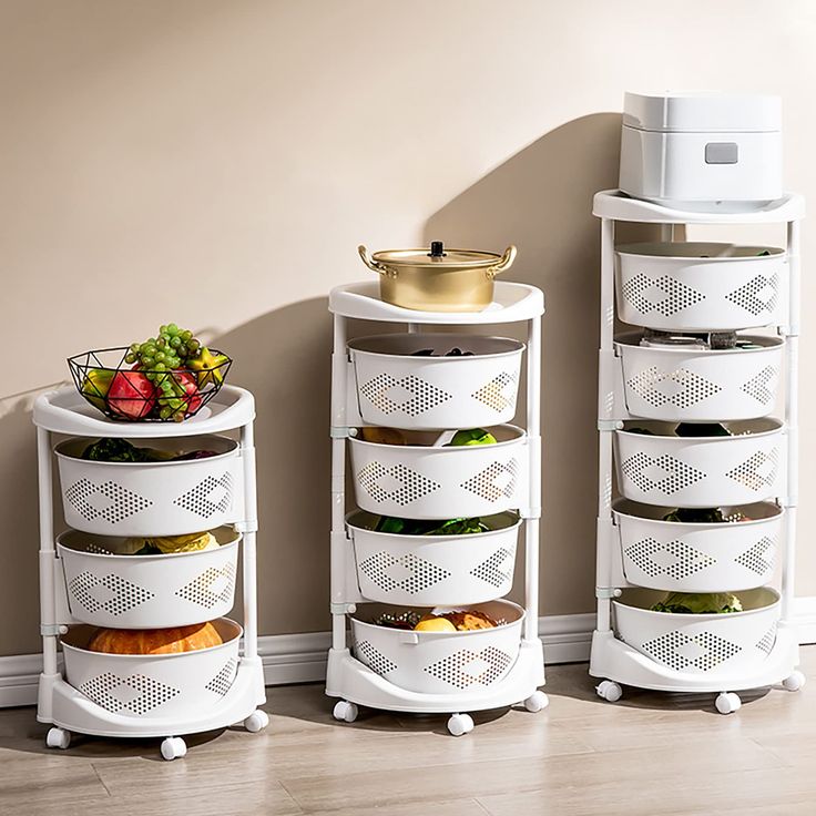 three white containers with food in them sitting next to each other on the floor near a wall