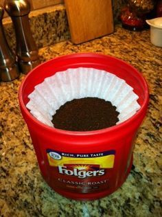 a red container filled with dirt sitting on top of a counter