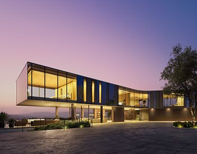 a large building with lots of windows and lights on it's sides at dusk