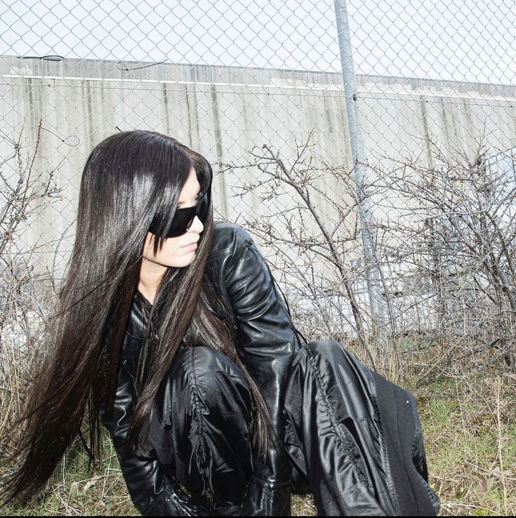 a woman with long black hair and sunglasses