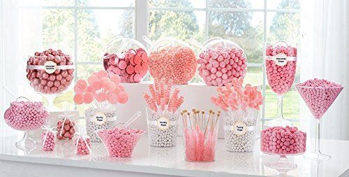 a table topped with lots of candy covered in pink and white frosted lollipops