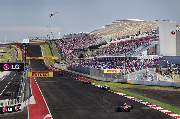 a race track with many cars on it and people in the stands watching from the sidelines