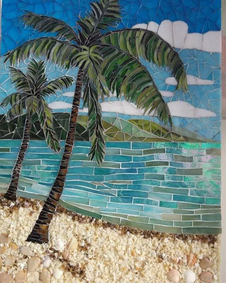 a mosaic tile wall with a palm tree and the ocean in the background, along with seashells