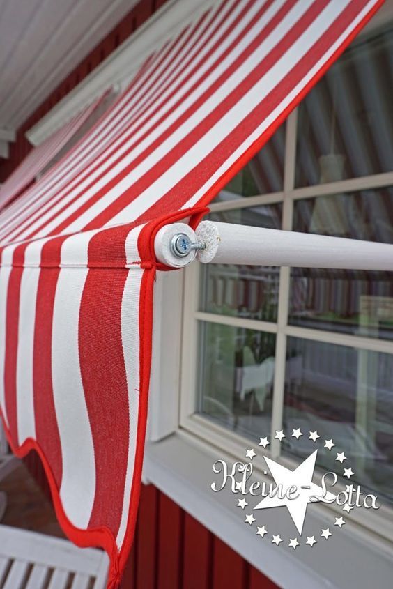 a red and white striped awning next to a window