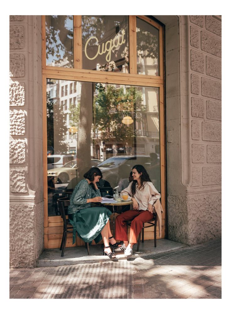 two people sitting at a table in front of a window with the words cuggies on it