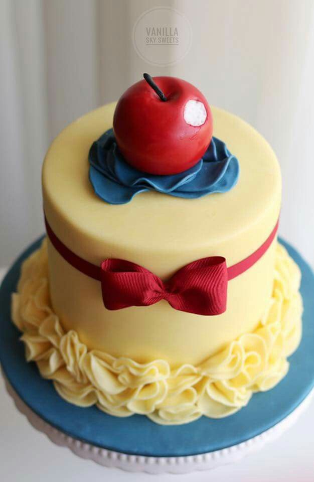 a cake with an apple on top and bow tie around the edge, sitting on a plate