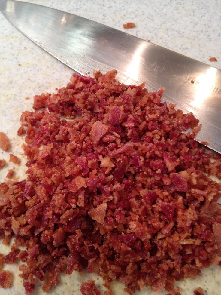 chopped meat sitting on top of a cutting board next to a knife