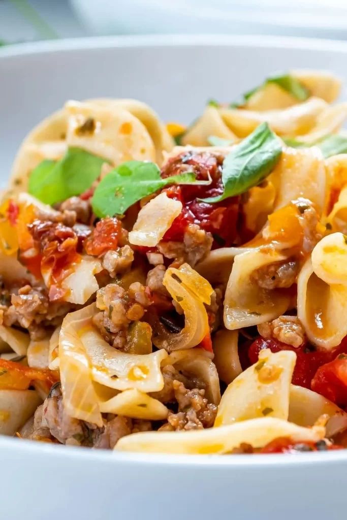 a white bowl filled with pasta and meat