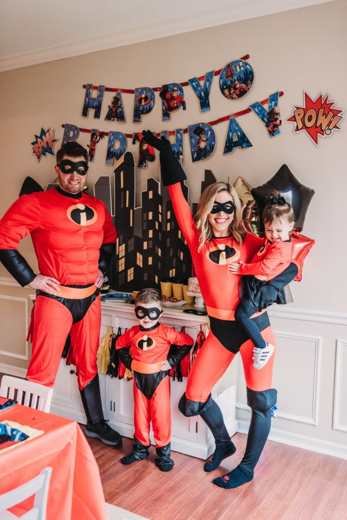 a man and woman dressed up as batman and catwoman pose for a family photo