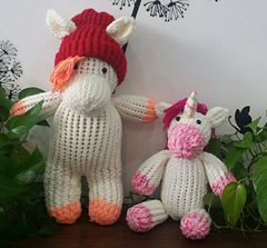 two crocheted stuffed animals sitting next to each other on top of a table