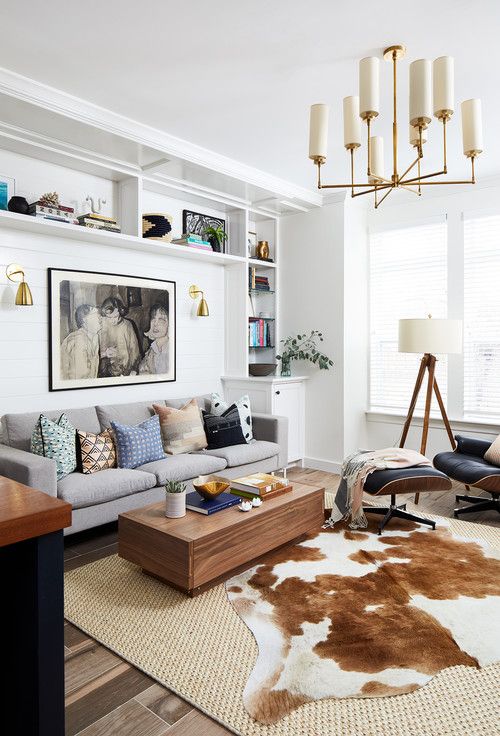 a living room filled with furniture and a cowhide rug