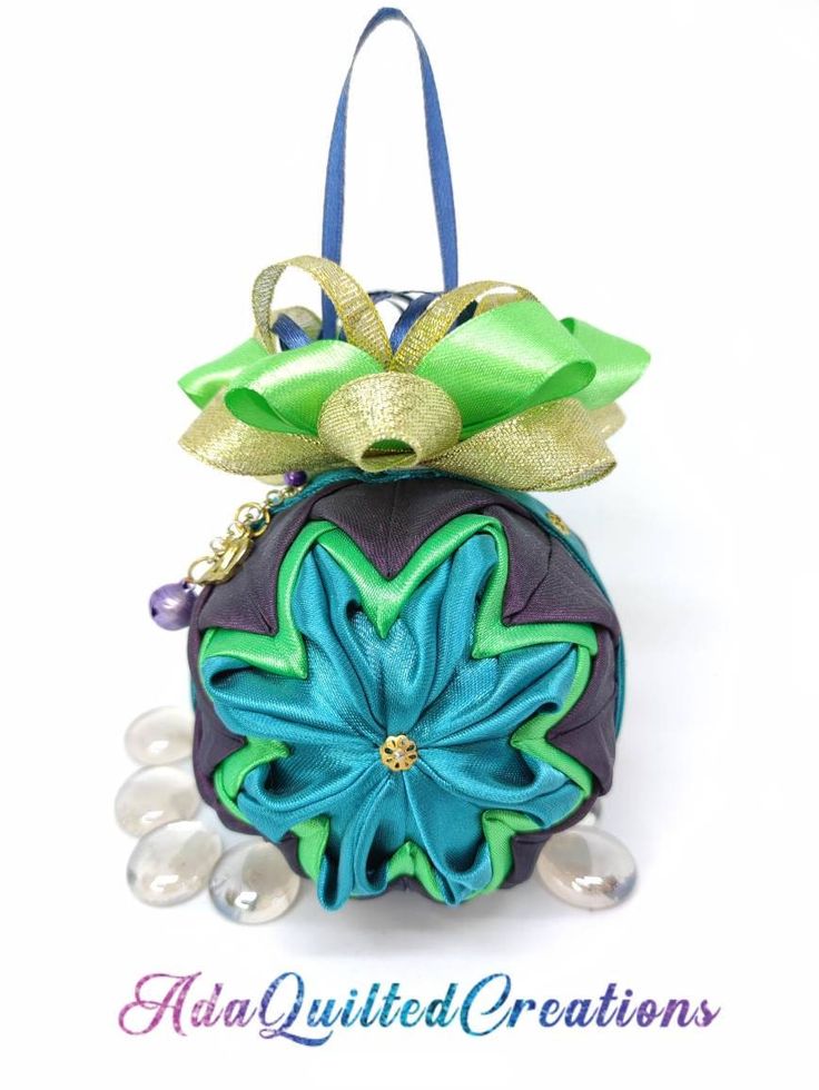 an ornament shaped purse with a bow on it's top and pearls around the bottom