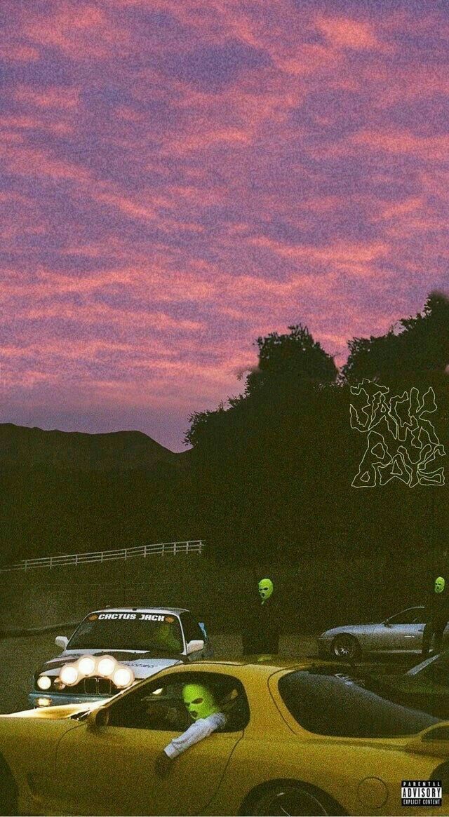 a yellow car parked in front of a parking lot at dusk with the sky painted pink and purple