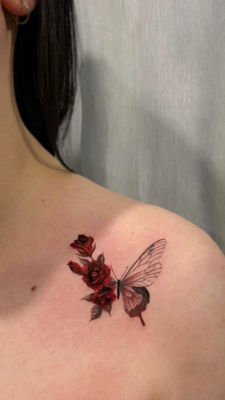 a woman's chest with red flowers and a butterfly tattoo on her left shoulder