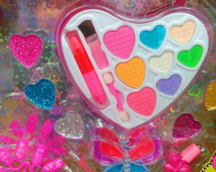 a heart shaped container filled with lots of different colored candies and other candy items