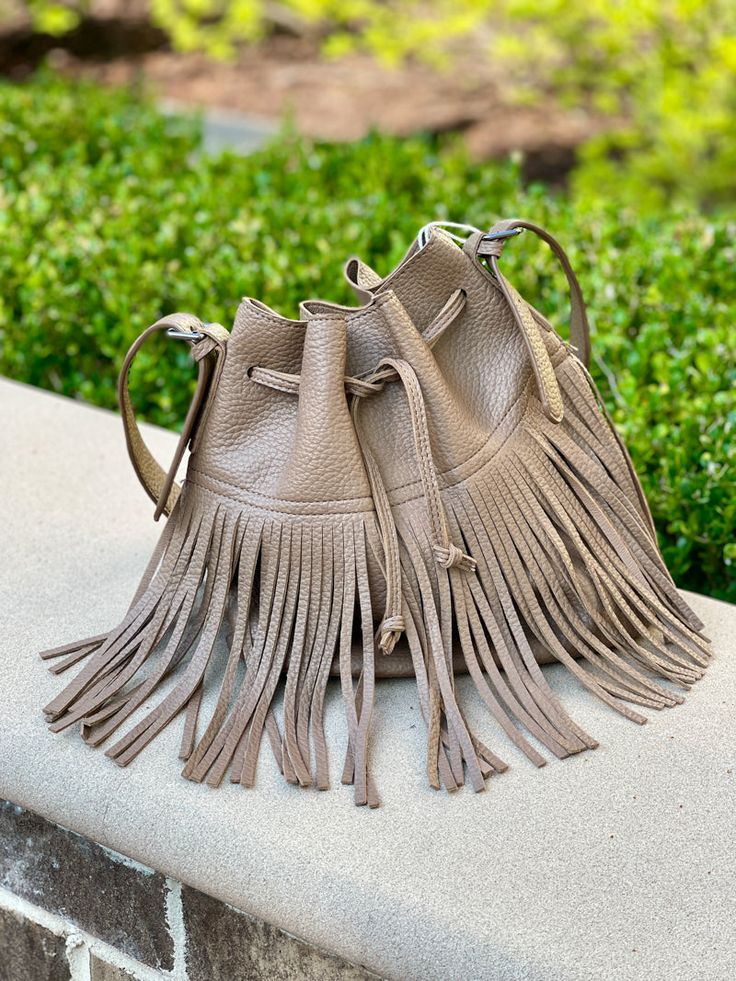 Introducing this trendy fringed bucket shoulder handbag, made from synthetic leather. It's perfect for your bohemian wardrobe! This taupe colored bag is not only aesthetically pleasing but also practical, making it an ideal purse for everyday use. Bohemian Fall Bags With Tassels, Trendy Fringe Bags For Fall, Trendy Fall Bags With Fringe, Trendy Brown Hobo Bag With Fringe, Spring Fringe Shoulder Bag For Everyday, Chic Daily Use Bucket Bag With Tassels, Spring Beige Shoulder Bag With Tassels, Chic Beige Fringe Bag, Chic Brown Fringe Hobo Bag