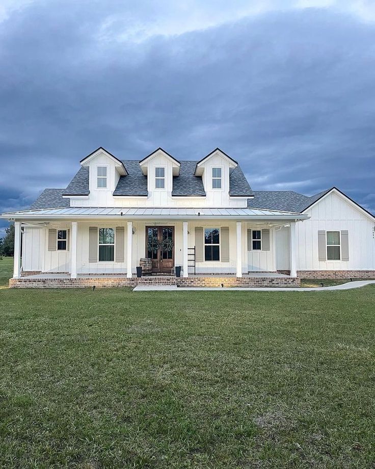 a large white house sitting on top of a lush green field