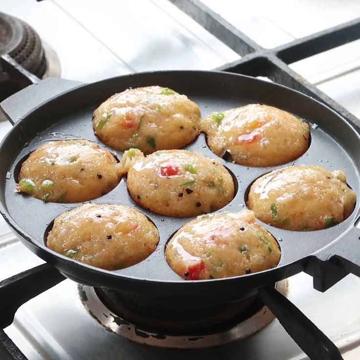 some food is cooking in a frying pan on the stove top with it's lid open