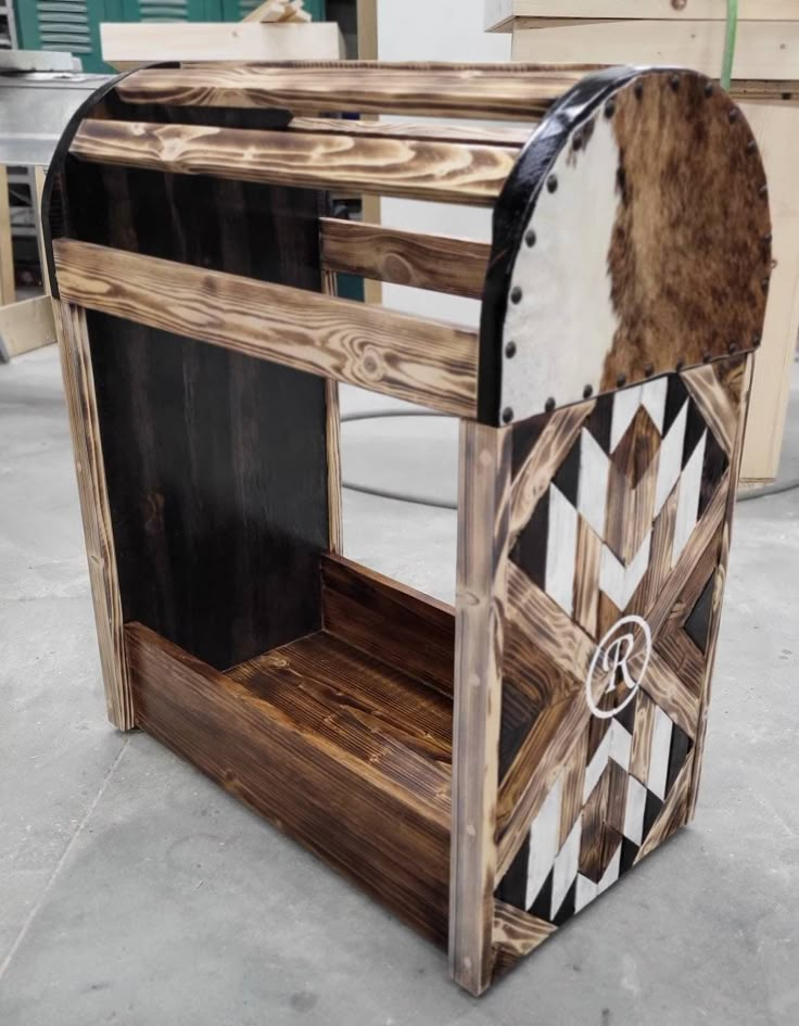 a wooden table with black and white designs on the top, sitting in a room