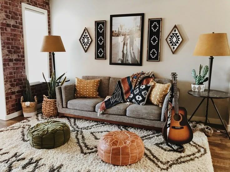 a living room filled with lots of furniture and pictures hanging on the wall above it