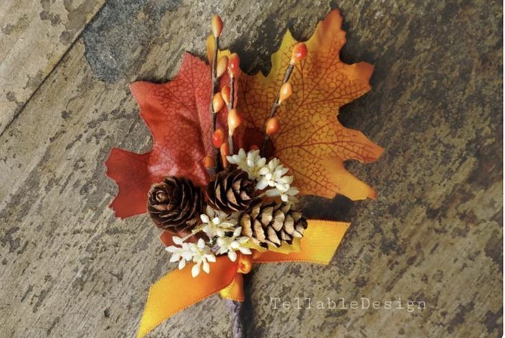 an arrangement of autumn leaves and pine cones