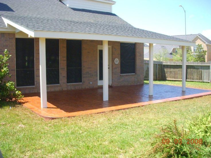 a house with a covered patio in the front yard and fenced in area around it