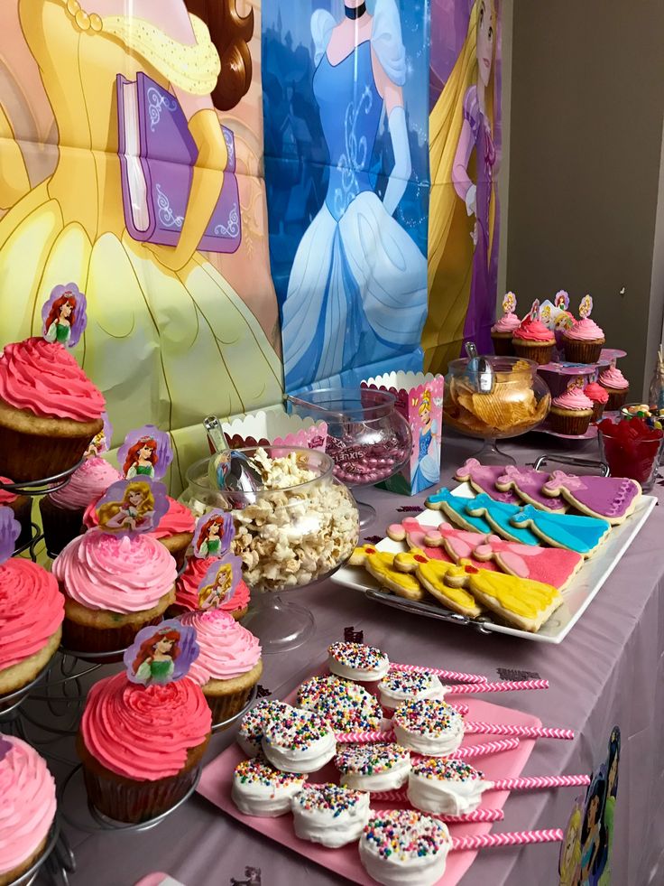 a table topped with lots of cupcakes covered in frosting