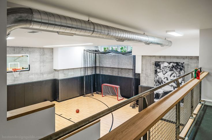 an indoor basketball court in the middle of a room with wood floors and metal railings