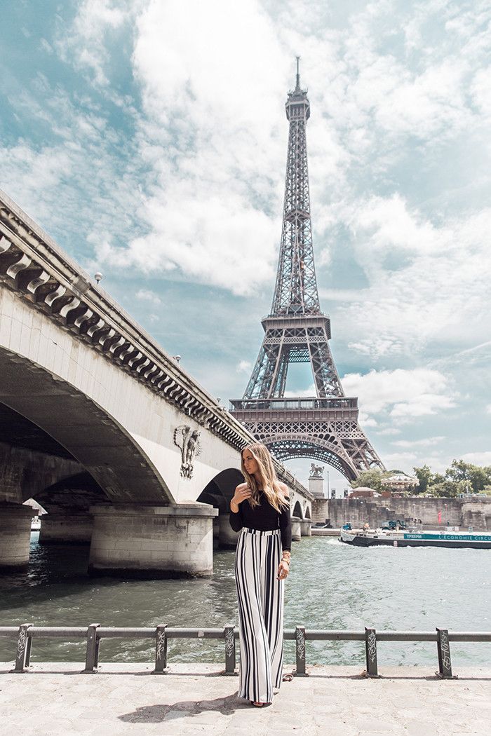 a woman standing in front of the eiffel tower