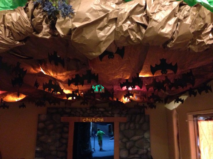 the ceiling is covered with paper and lights for halloween decorations, while bats hang from the ceiling