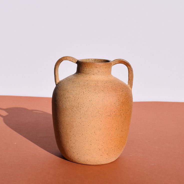 a brown vase sitting on top of a table