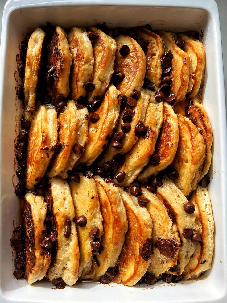 a casserole dish filled with sliced bread and chocolate chips on the top side