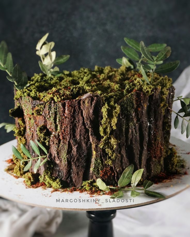 there is a cake that has been decorated with green and brown leaves on top of it