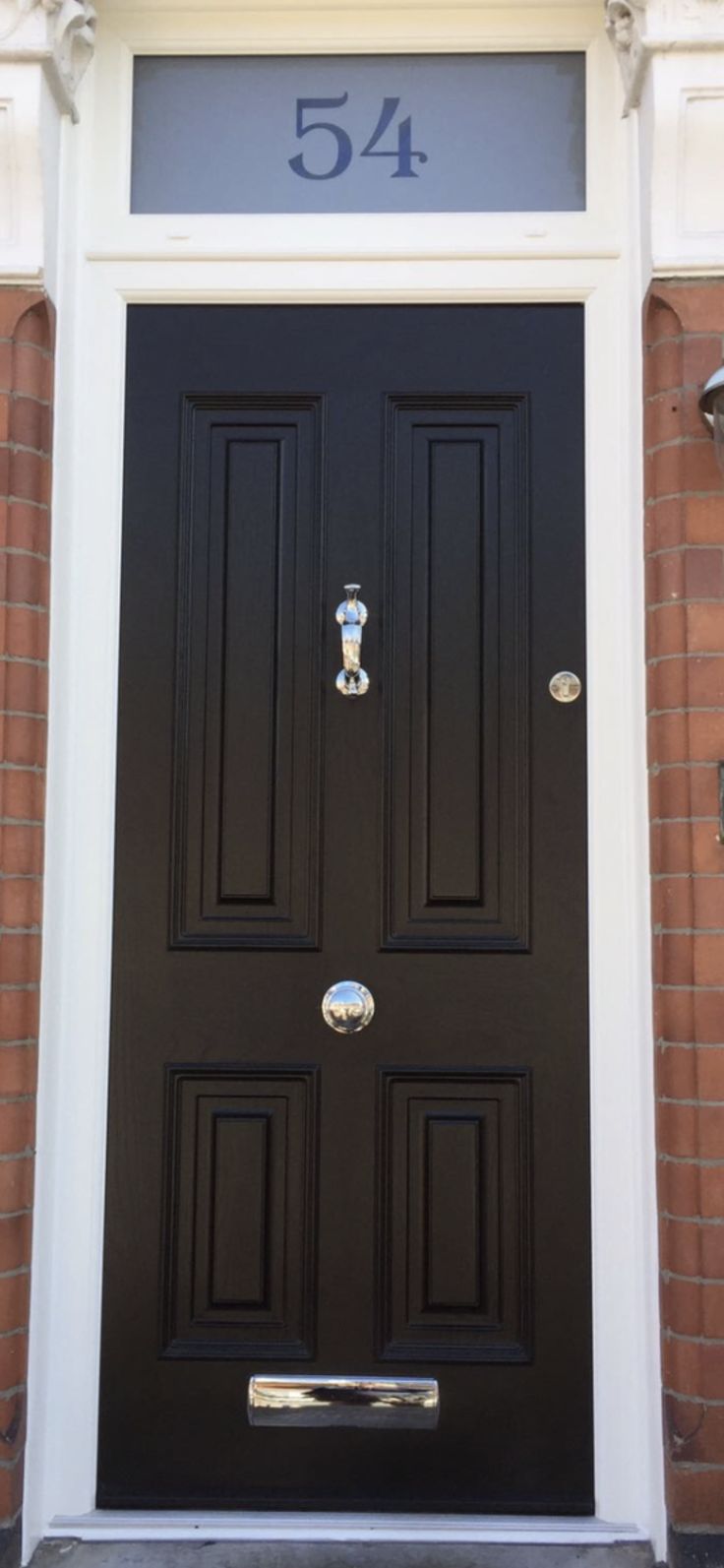 a black front door with the number 544 on it's side and two lights