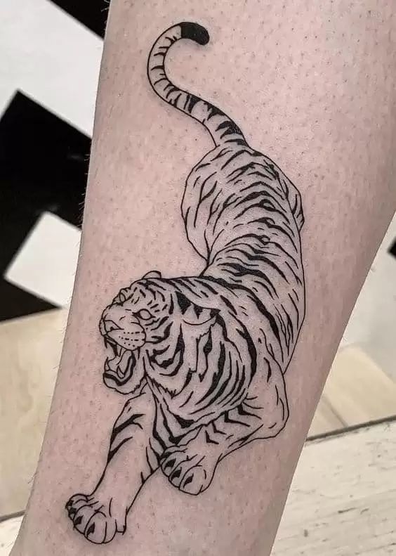 a black and white tiger tattoo on the leg