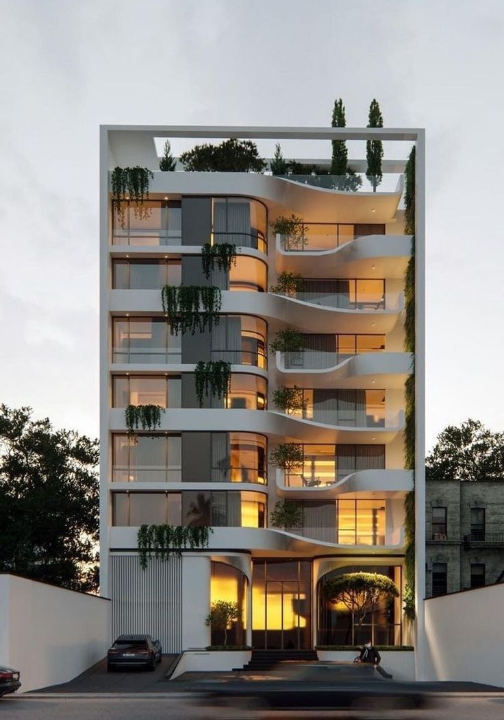 an apartment building with plants growing on the balconies and in front of it