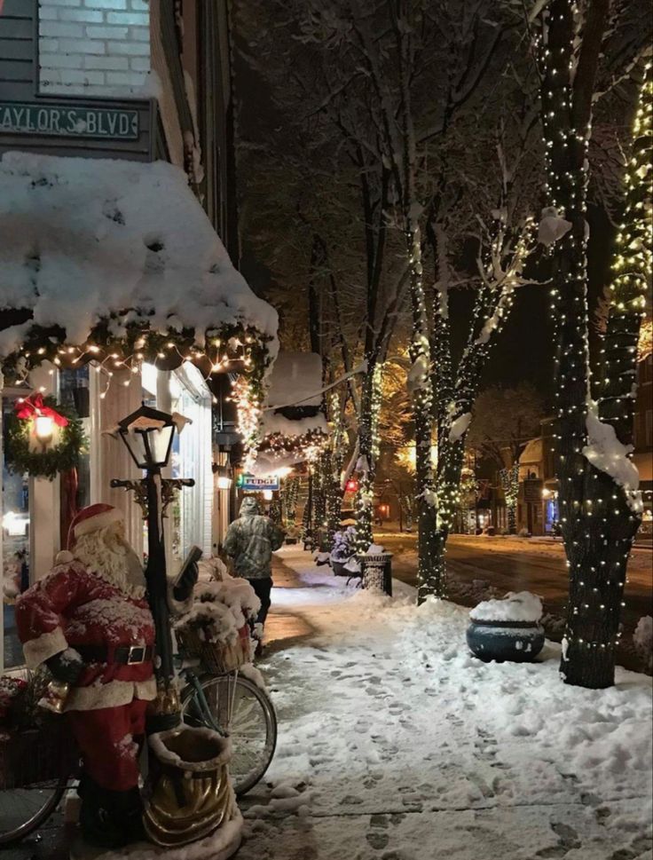 a snowy street with christmas lights and decorations