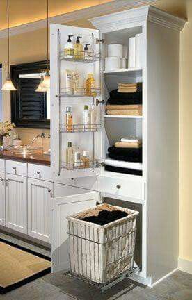 a white cabinet with shelves and baskets in it