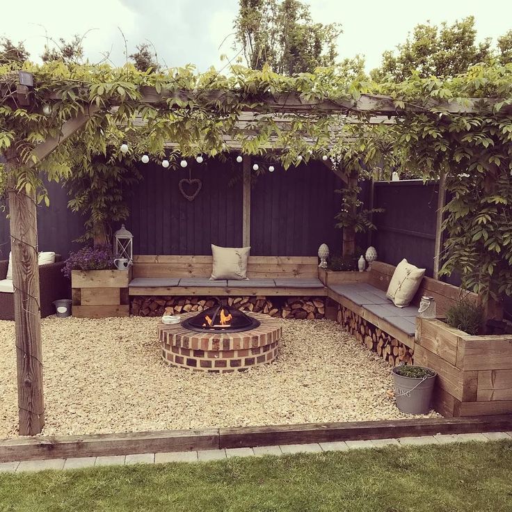 an outdoor fire pit surrounded by wooden benches