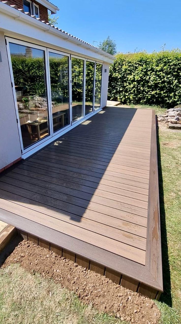 a wooden deck with sliding glass doors on it