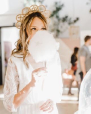 a woman in a white dress is holding something