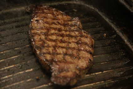 a steak is being cooked on the grill