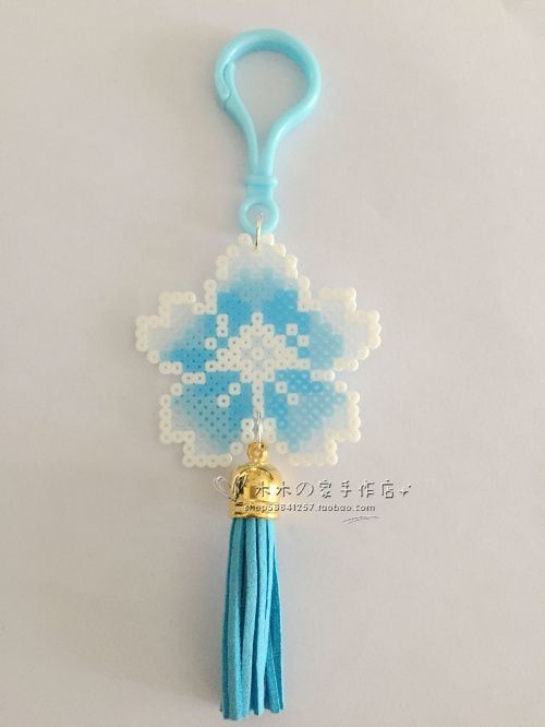 a key chain with a cross on it and a tassel hanging from the end