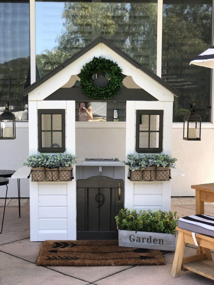 a dog house with plants in the front