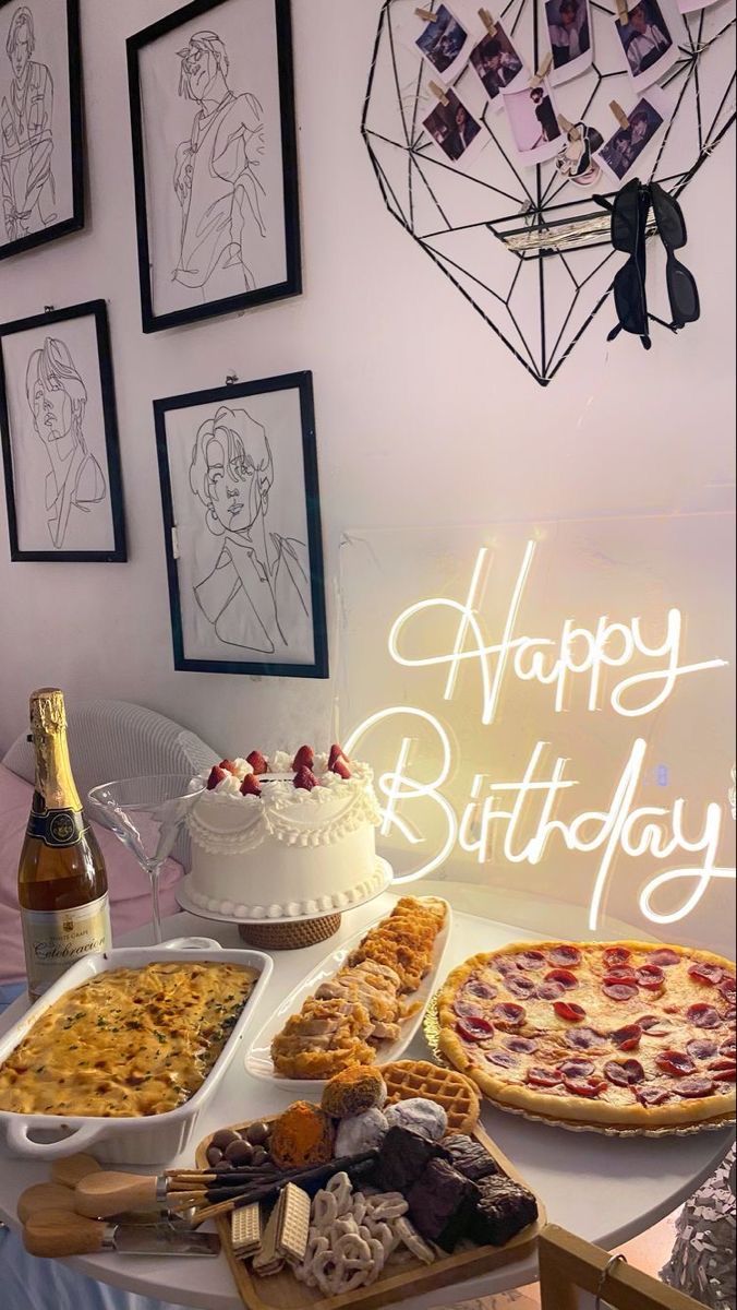 a table topped with pizzas and cakes next to bottles of wine on top of a table