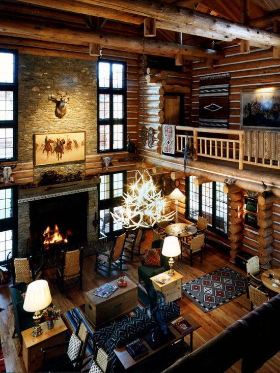 the inside of a log cabin with lots of windows and wood flooring is shown