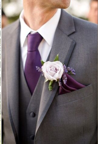 a man wearing a suit and tie with a flower in his lapel pin on his lapel