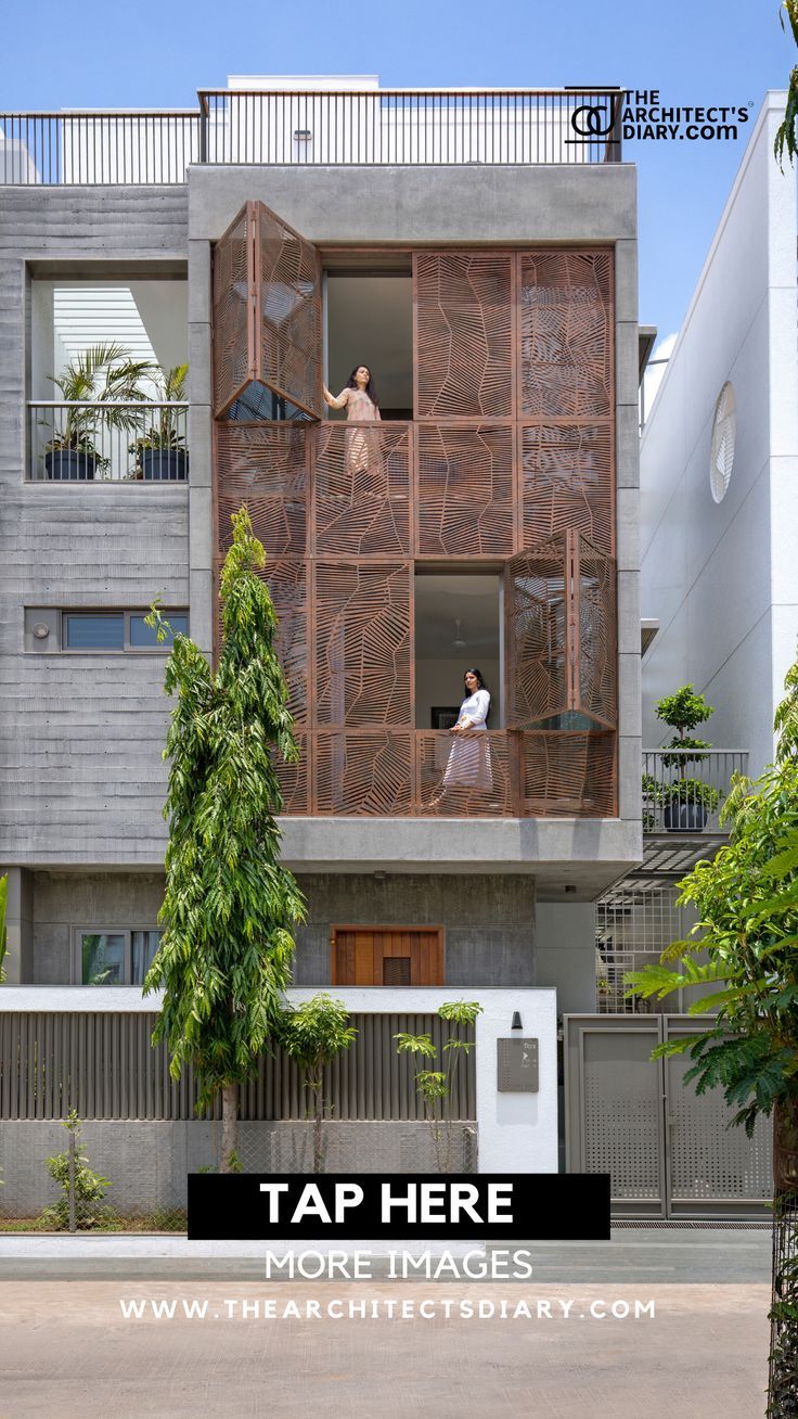 an apartment building with people standing in the windows