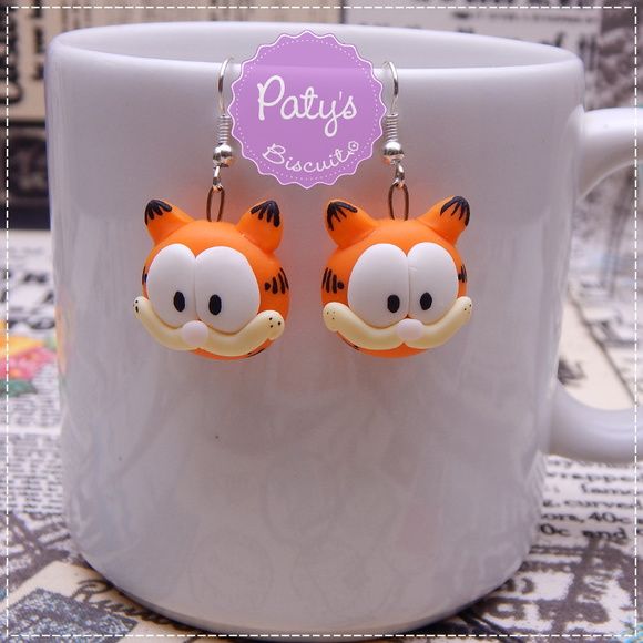 a pair of orange and white tiger earrings on a mug with a purple tag that says patty's boutique