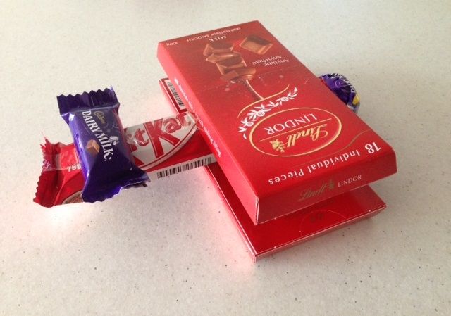 two bars of chocolate sitting on top of each other next to some candy bar wrappers